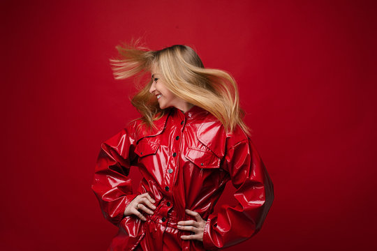 Portrait of handsome caucasian female with long fair hair in red leather costume enjoys of her life