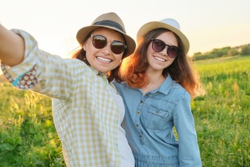 Fototapeta premium Happy smiling mother and teen daughter taking selfie photo
