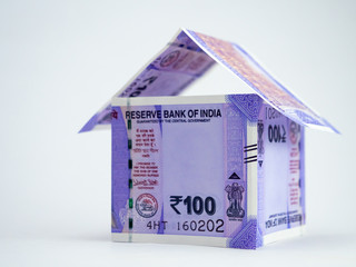 Low angle close-up shot of a home made with money notes showing loan and finance concept.