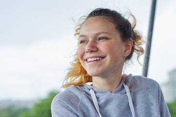 Closeup portrait of teenage girl of 14, 15 years old in gray sweatshirt