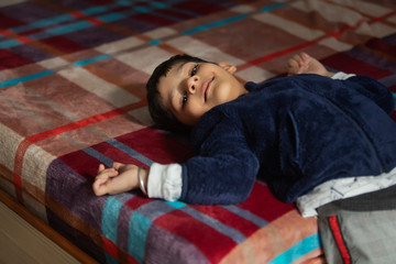 Young boy lying on the bed and smiling. (Children)
