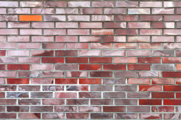 Obraz premium one orange-colored brick stands out from the other bricks that make up the wall fragment