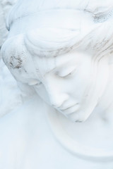 Close up of ancient statue of beautiful sad angel feeling pain and sorrow.