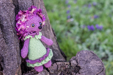 Crochet toy hedgehog on natural background.
