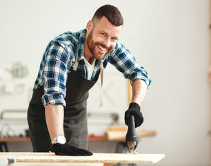 young male carpenter working in  workshop