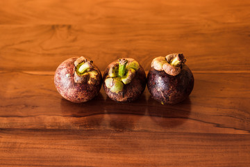 Obraz premium Purple mangosteen on wooden table.
