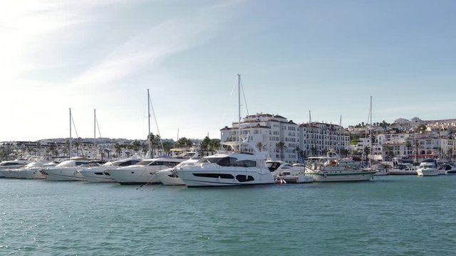 MANILVA, MALAGA / Spain - December 14 2019: Beautiful panoramic view of "Puerto de la Duquesa" Yachts and boats docked in the Harbour. Luxury Apartment Urbanisation and Restaurants. No camera movement