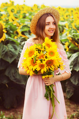 Beautiful smiling young woman in a white shirt stands in the fie