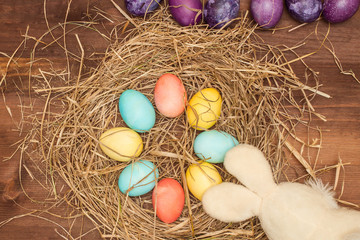 Easter, Easter eggs collection as background.
Easter eggs on a brown wooden table.
Easter eggs and hay. Orange, yellow, turquoise  eggs in a nest arranged in a circ. Easter bunny and eggs