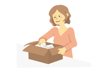 シャツを段ボールに入れる女性