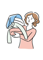 洗濯物の山を抱えて困る女性