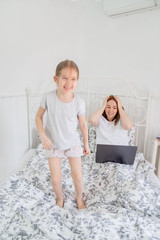 little girl interferes to work mom at home.