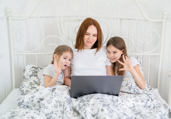mom with kids talk relatives via video connection