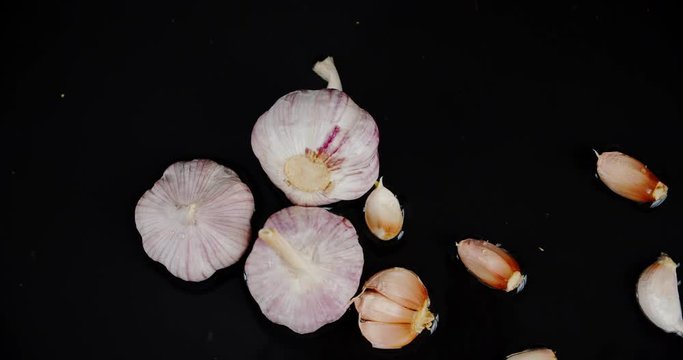 Cloves of garlic fall to the water with a splash.