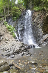 small waterfall and stones in the mountain park