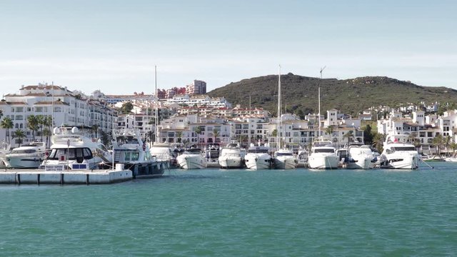Beautiful panoramic view of "Puerto de la Duquesa" Yachts and boats docked in the Harbour. Luxury Apartment Urbanisation and Restaurants. No camera movement