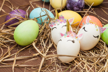 Easter eggs and hay collection. Multi-colored eggs in a row.
Easter eggs on a brown wooden table.