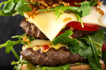 Double cheeseburger with a lot of arugula and sauces