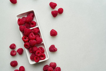 Bowl of delicious ripe raspberries on white background, top.