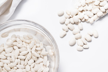 White beans soaked in water in glass bowl