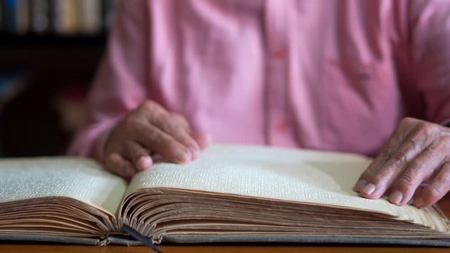 elder reading a braille book