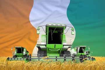 four light green combine harvesters on rural field with flag background, Cote d Ivoire agriculture concept - industrial 3D illustration