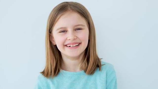 Positive little girl laughing indoors