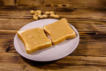 Sandwiches with peanut butter in plate on a wooden table
