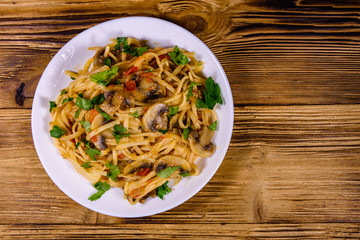 Pasta with mushrooms and tomato sauce in a plate. Top view