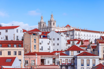 Fototapeta na wymiar A classic hilltop view of houses in Lisbon. On the top Monastery of St. Vincent Outside the Walls (Igreja de São Vicente de Fora) Lisbon, Portugal