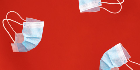 Medical protective mask on red background. Minimal medical concept. Disposable surgical face mask.