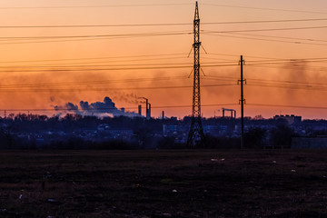 View on smoke pipes of the factory at sunset