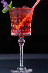 red refreshing alcoholic cocktail made from cherry juice decorated with mint and flowers