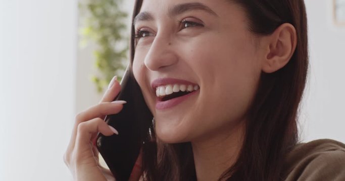 Playful girl talking on cellphone, flirting with boyfriend at home