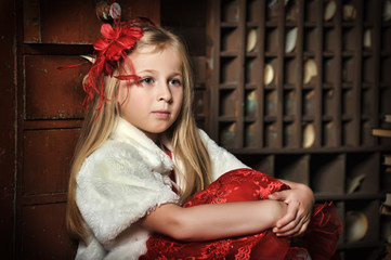 blonde girl in a red elegant dress with a red hairpin in her hair and a white fur cape
