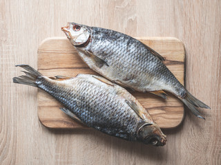 Dried fish on a wooden plate.
