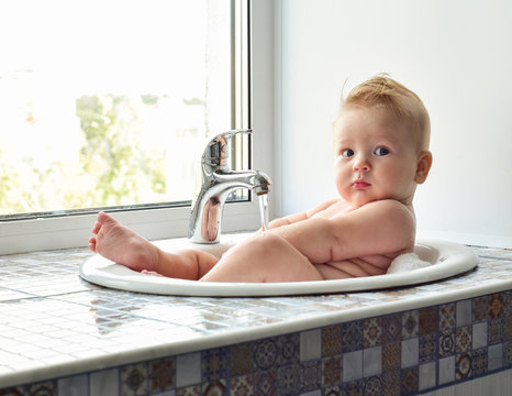 Cute Adorable  Baby Having Bath In Washing Sink