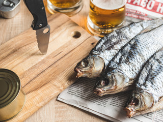 close-up dried fish, vintage glass of beer on a dark wooden background.