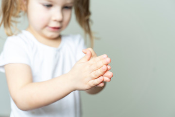 little girl 4 years old in a white T-shirt rubs the sanitizer on her hands. hand treatment in the conditions of the emulsion of coronavirus KOVID-19