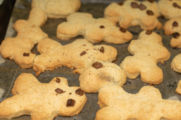 Appetizing homemade cookies in the shape of men on a baking sheet. tasty background