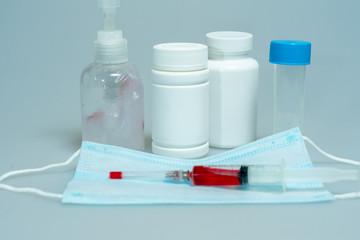 tablets in jars, antiseptic gel, disposable mask, syringe with a red vaccine. development of a vaccine against Covid-19 by scientists