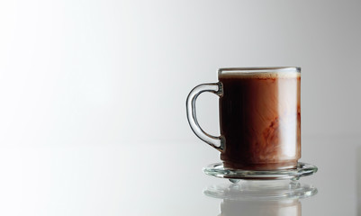 Latte coffee in glass cup on a glass table.