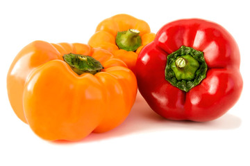 On an isolated white background are three ripe, fresh colorful peppers.