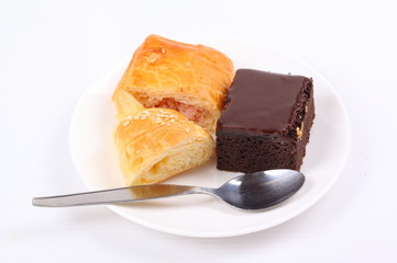 Fresh and tasty croissant and Chocolate cake on white background