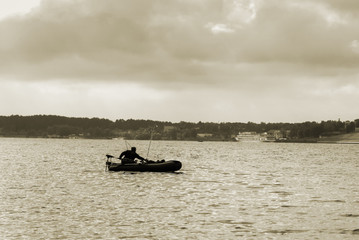 Silhouette of a fisherman in a boat on a river