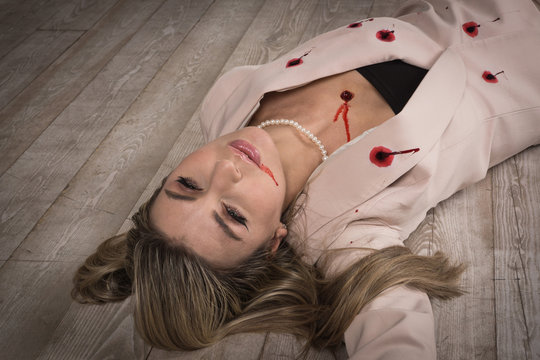 Crime scene (imitation). Pretty business woman lying on the floor. She shot in the chest.