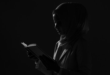 girl is reading Quran. The Quran is indicated as the guided book for all Muslim and it is direction to be on the heaven of God. Mosque, Islam, religion and knowledge concept.