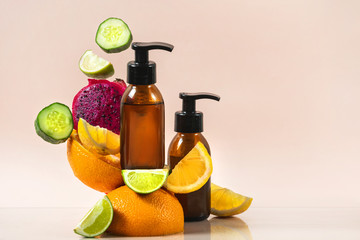 Two glass bottle with fresh organic cosmetics near fruits