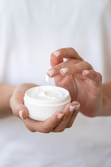 Woman holding container with soft cream in hands