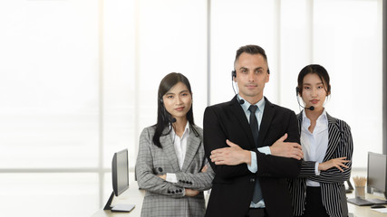 Young man and women, professional operators customer support  team with headsets standing with confidence and service mind in a call center office. Cultural diversity nationality in workplace.